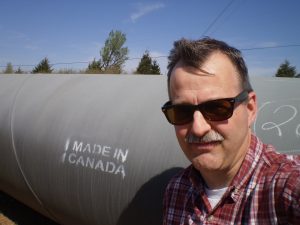 Robert S. Latimer in front of pipeline 
